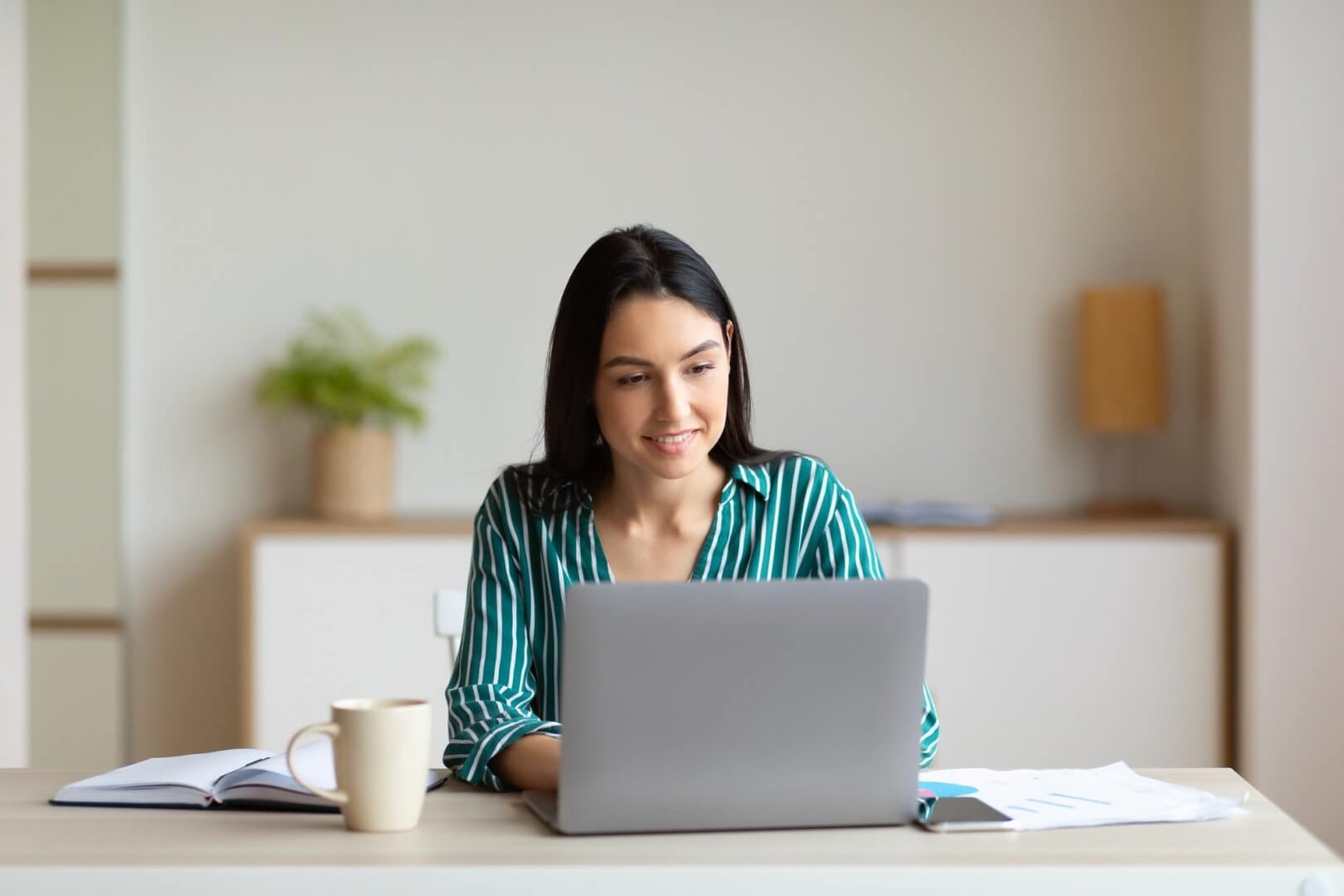 businesswoman-working-on-laptop-sitting-at-workplace-in-office.jpg