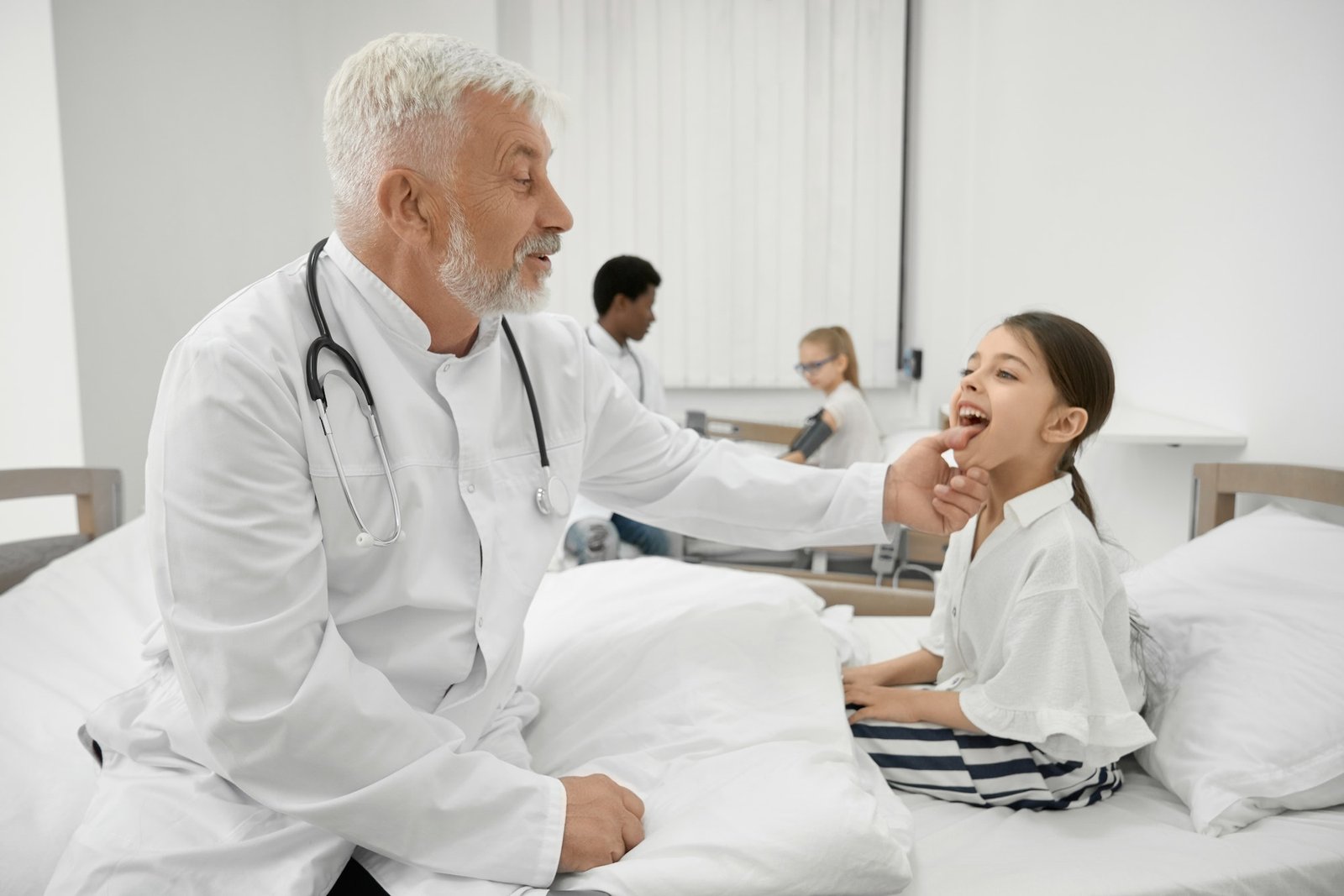 Eldery doctor examinating throat of schoolgirl on couch